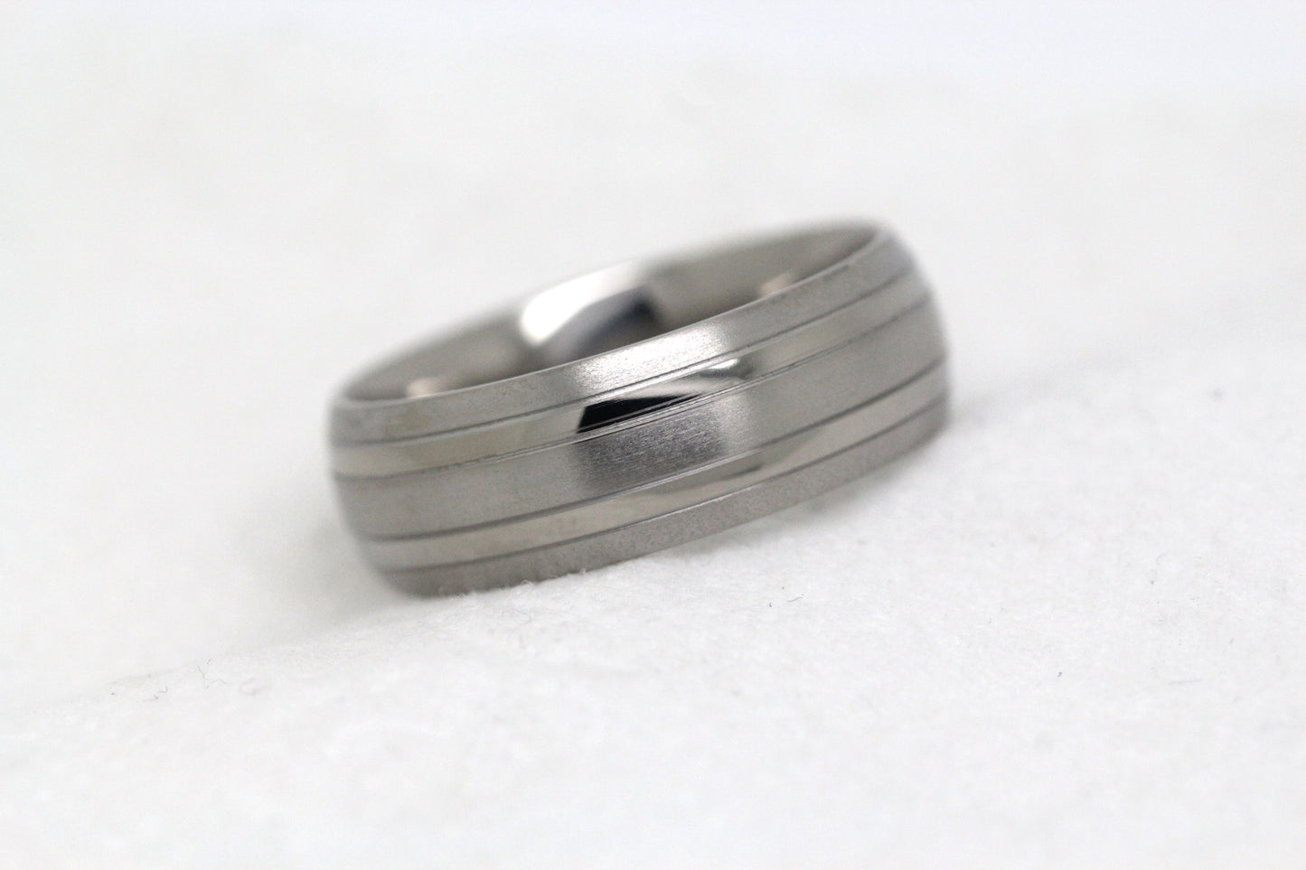 Matte 8mm titanium wedding ring for men and women with polished lines, perfect for anniversaries and engagements.