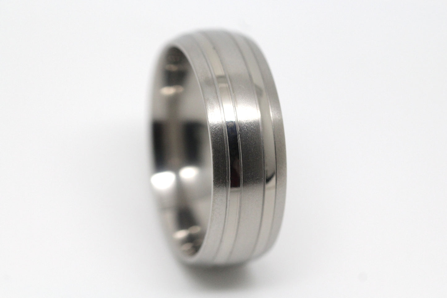 Titanium ring with a textured design on a white background