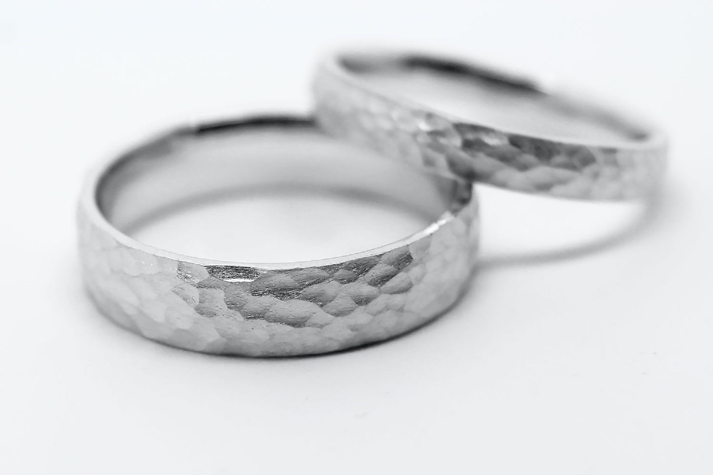 Two white gold rings with hammered design on a white background. One 6mm width, the second is 3mm width