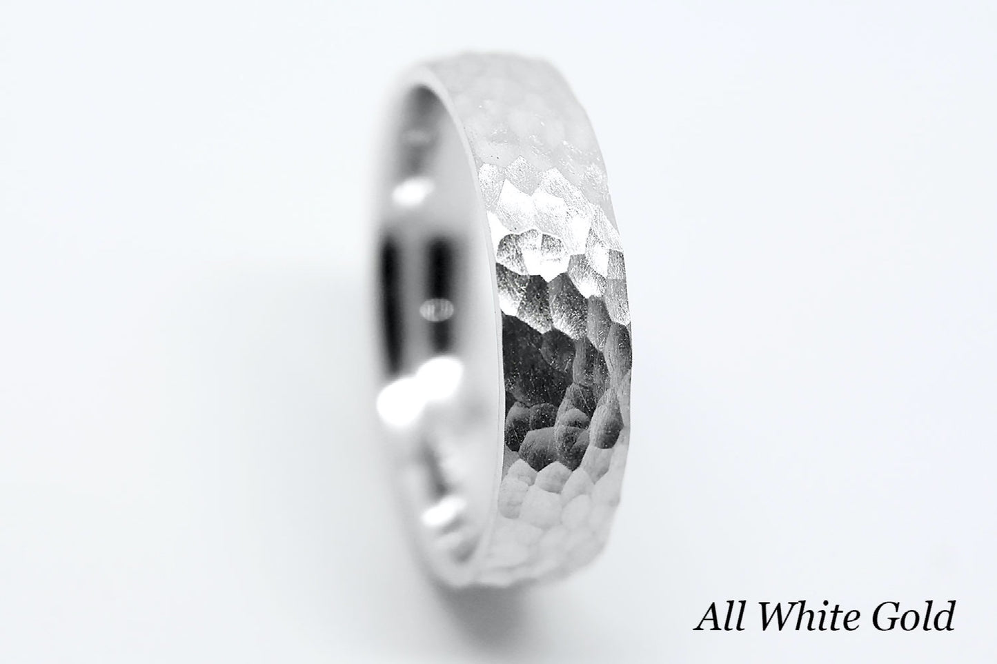 White gold ring with hammered design on a white background