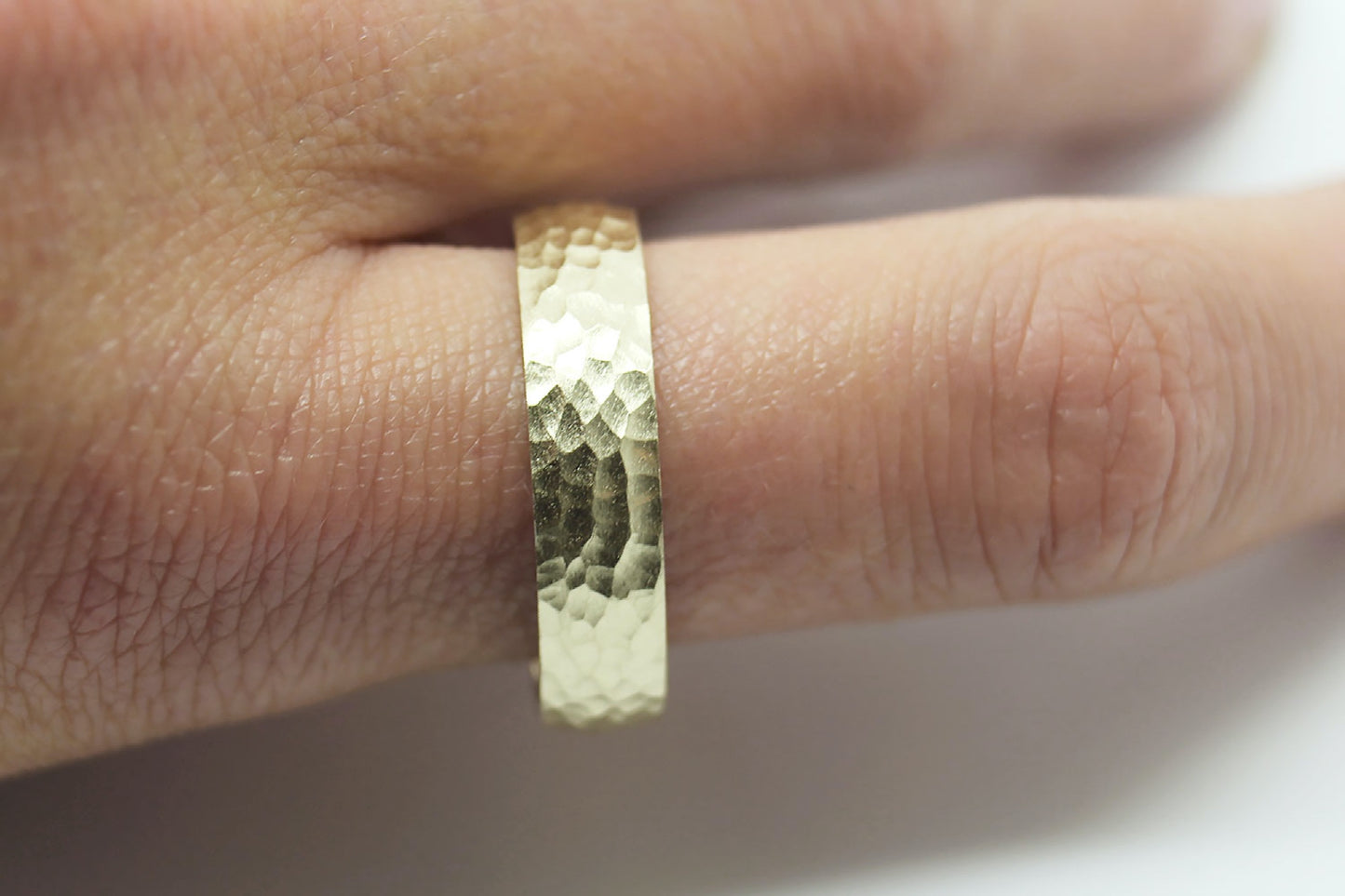 Hammered gold ring on a finger