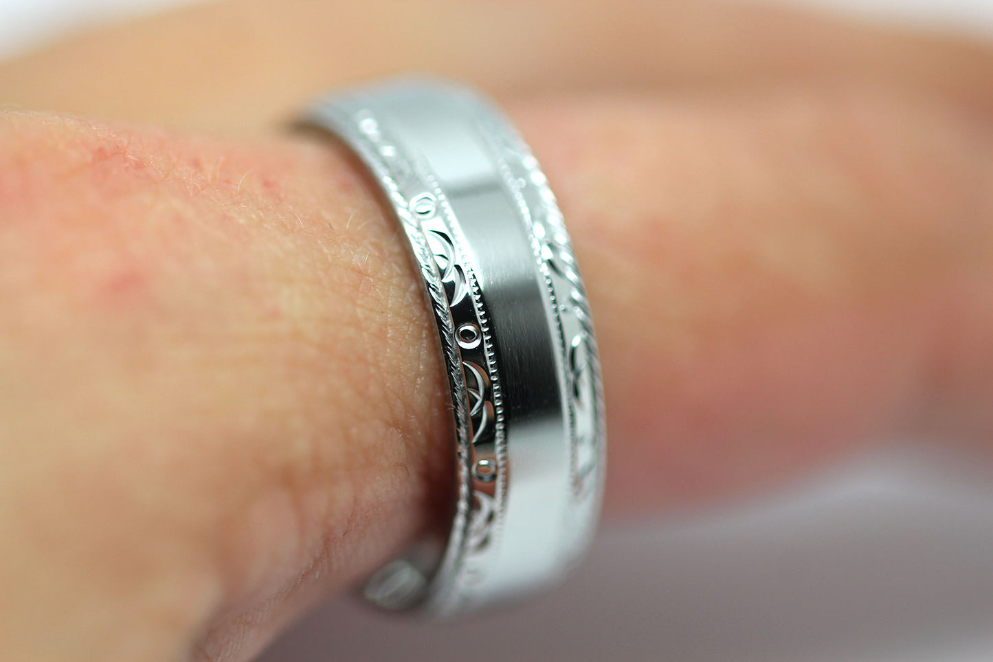 Polished titanium wedding ring for men and women, featuring intricate filigree design and 6mm width.