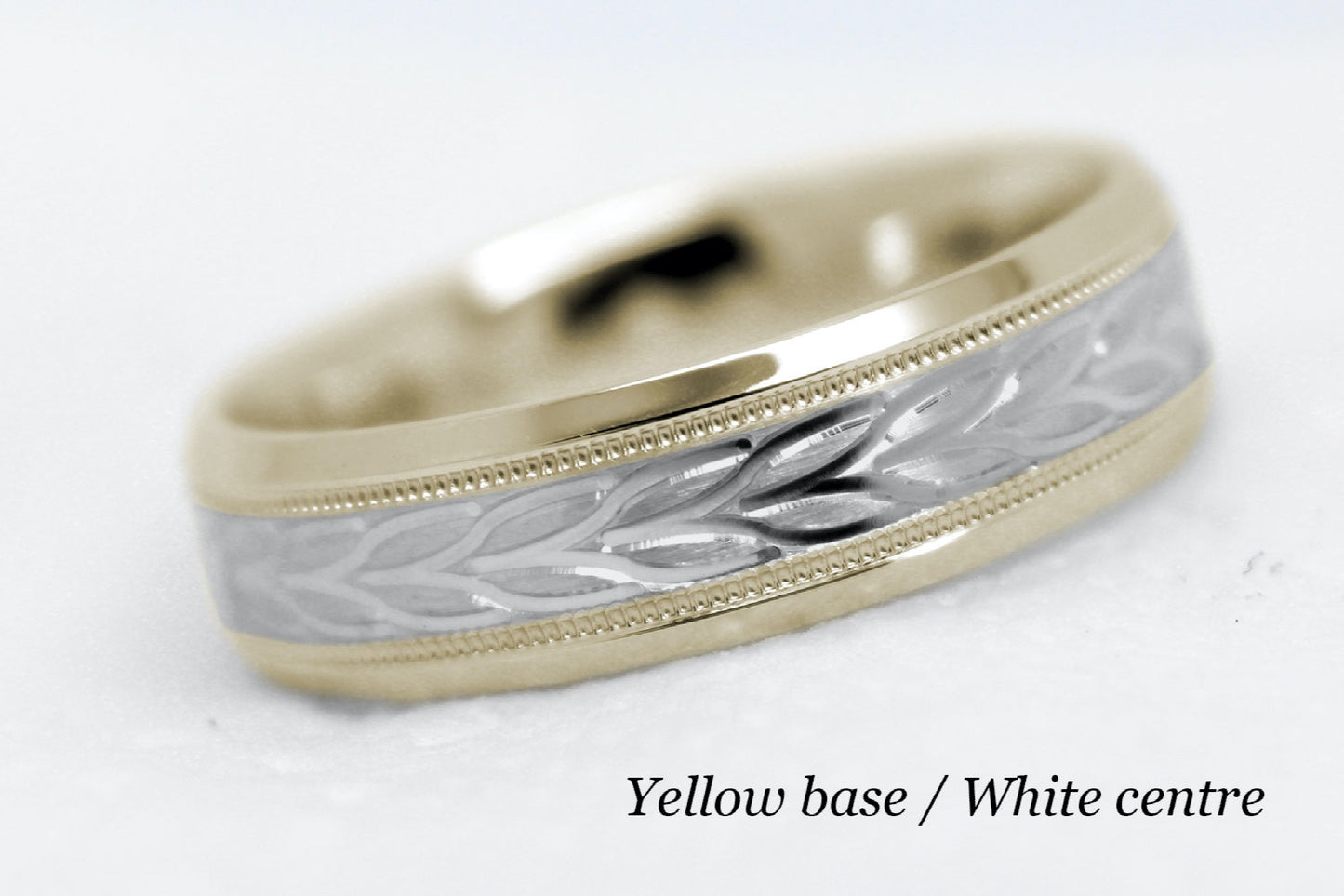 beveled wedding band for men with yellow gold beveled base and white gold floral brushed design