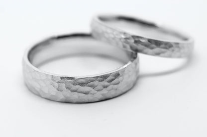 Two white gold rings with hammered design on a white background. One 6mm width, the second is 3mm width
