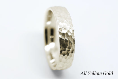 Hammered yellow gold ring on a white background.