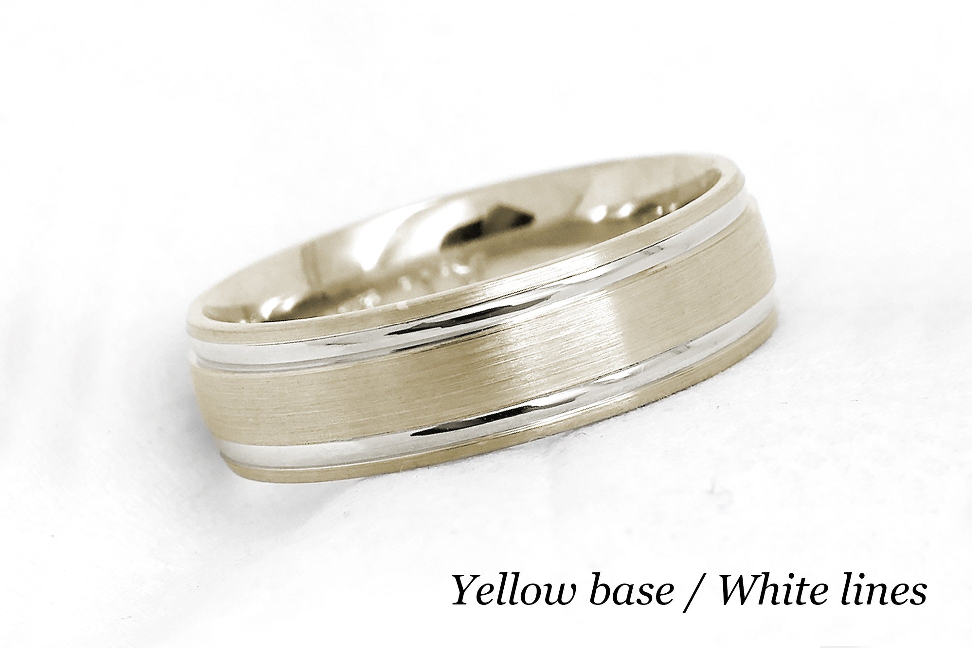 solid gold wedding band for men and women in yellow gold base and white gold lines. Brushed finish with polished lines.