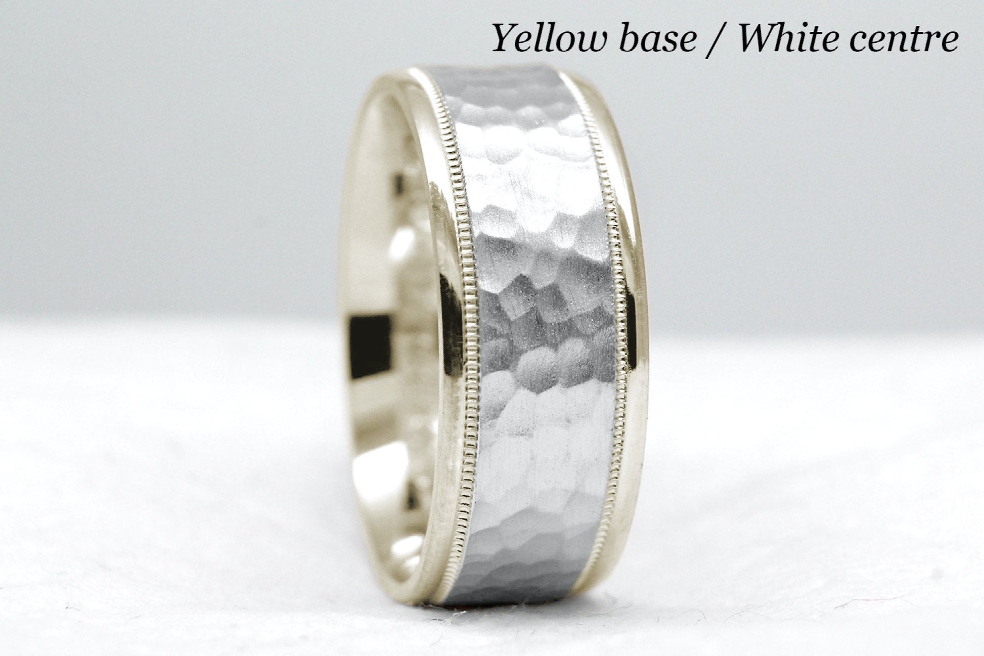 yellow gold base and white gold centre. 8mm hammered wedding band for men and women