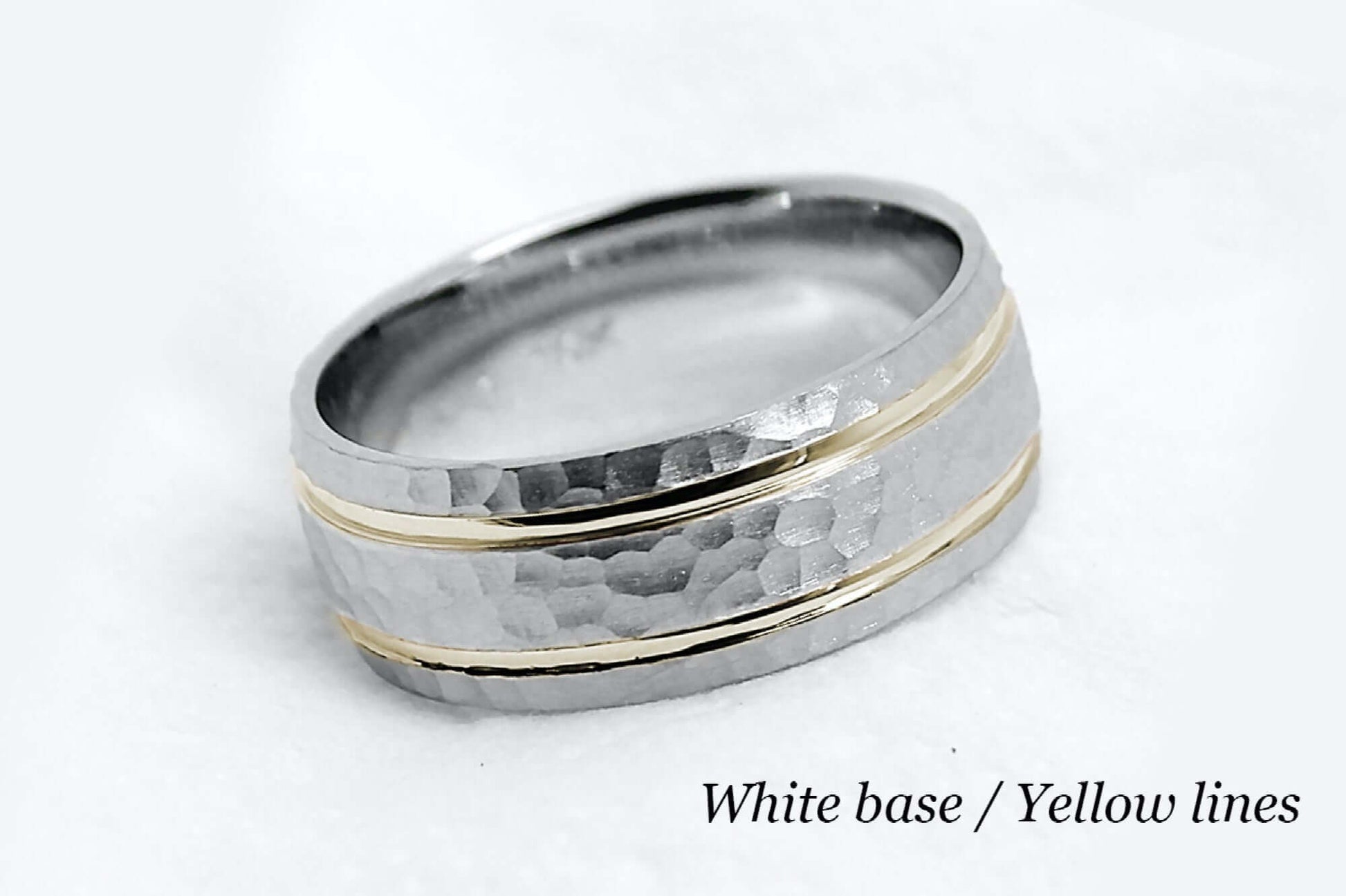 8mm wide Solid white gold ring for men featuring hammered finish and yellow gold polished lines. Low dome look with comfort fit.